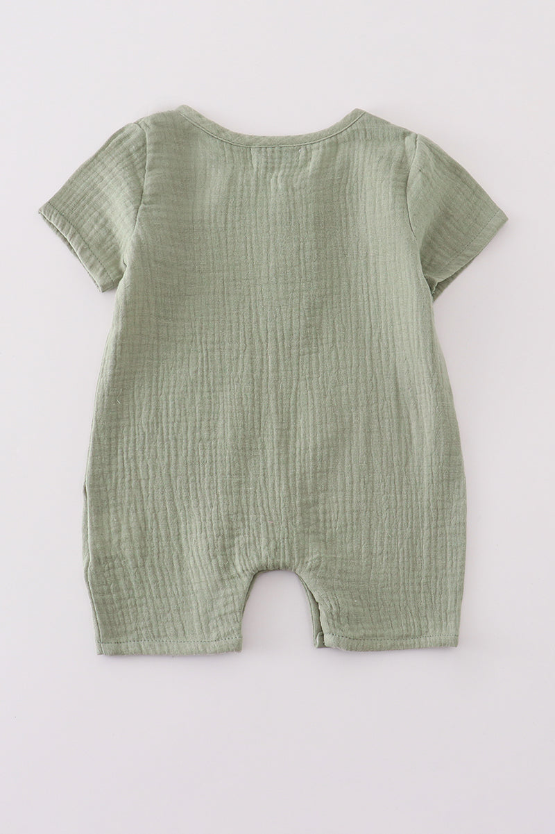 Green baby romper on a white background