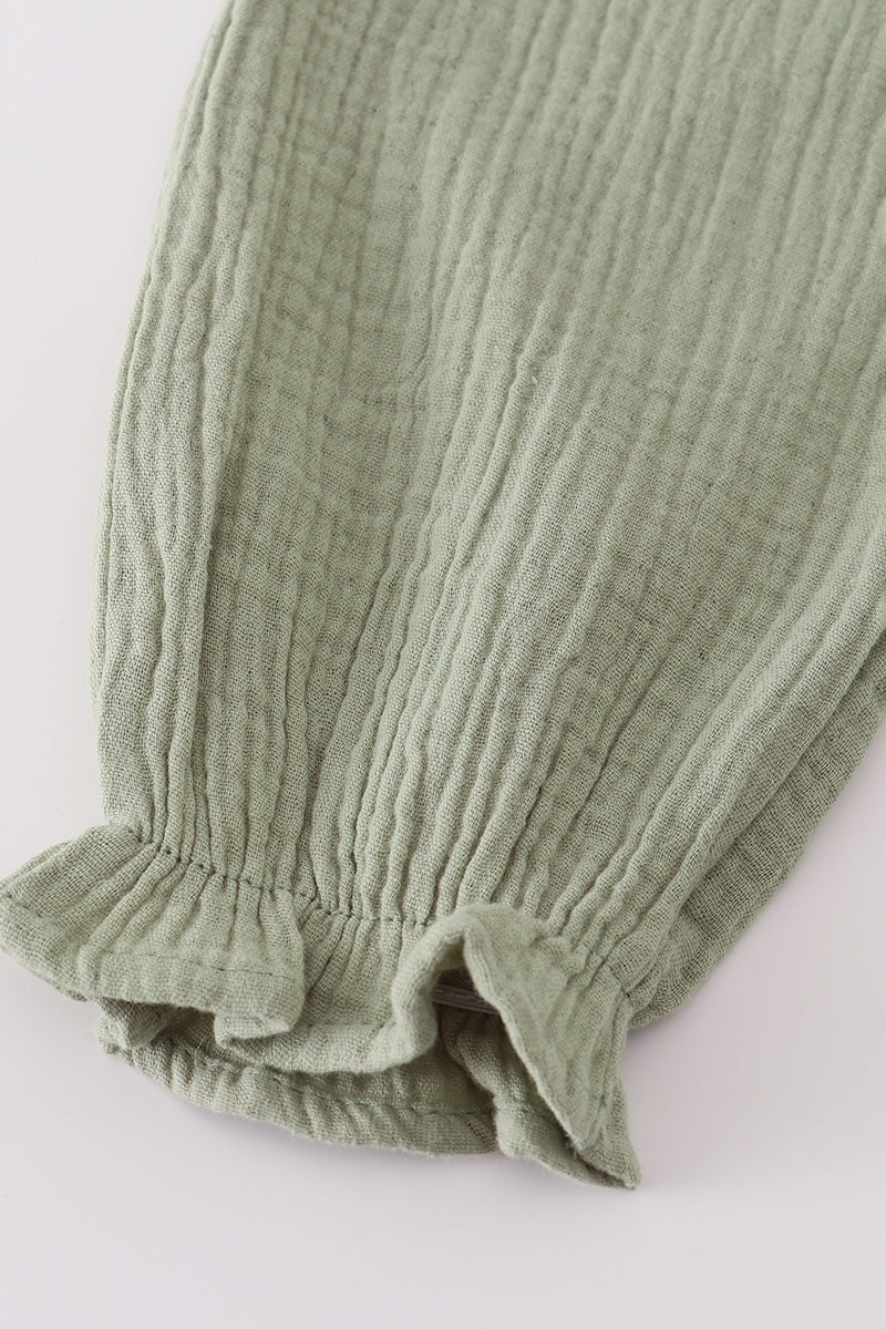 Green ribbed baby leg warmers on a white background