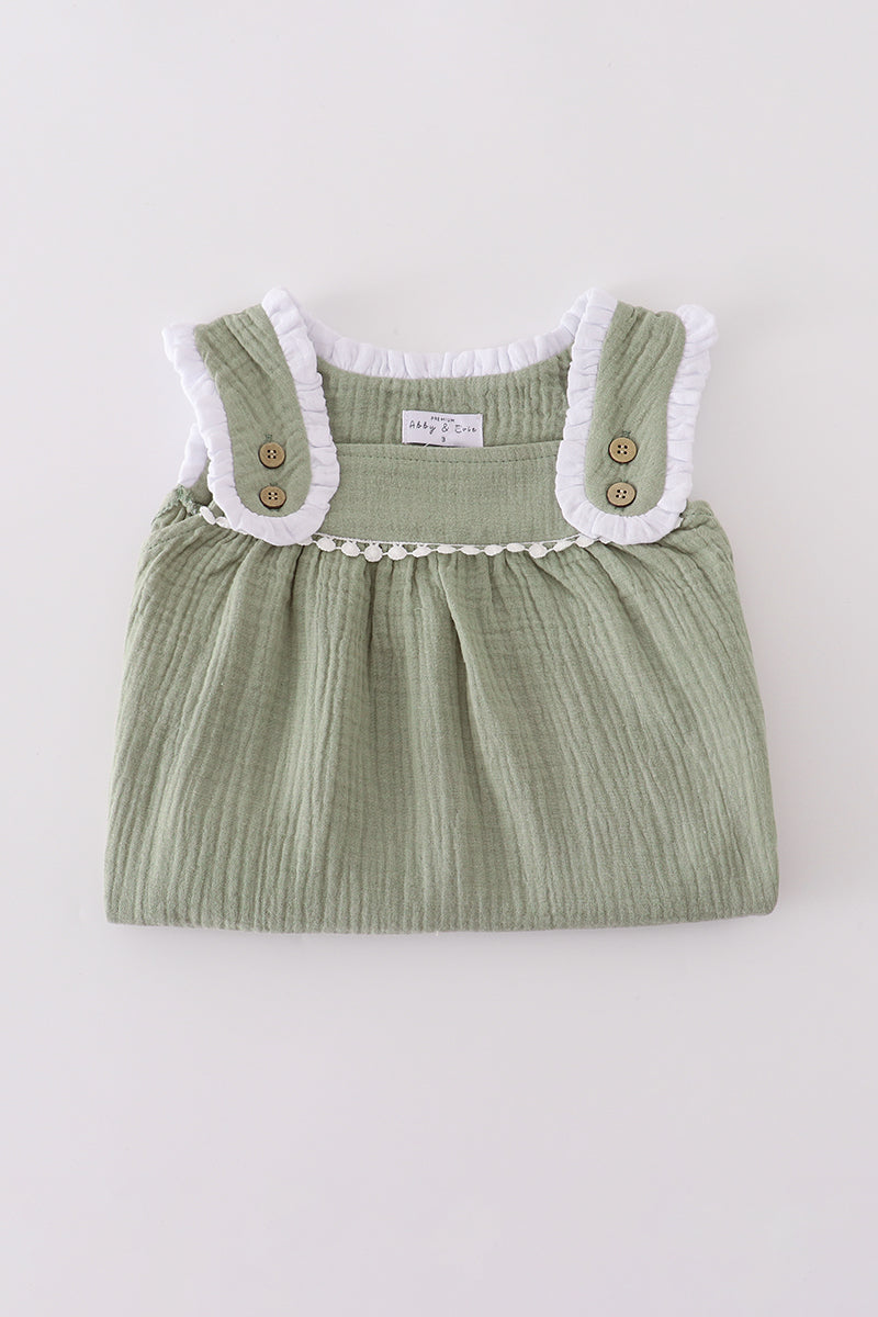 Green baby dress with white lace collar on a light gray background