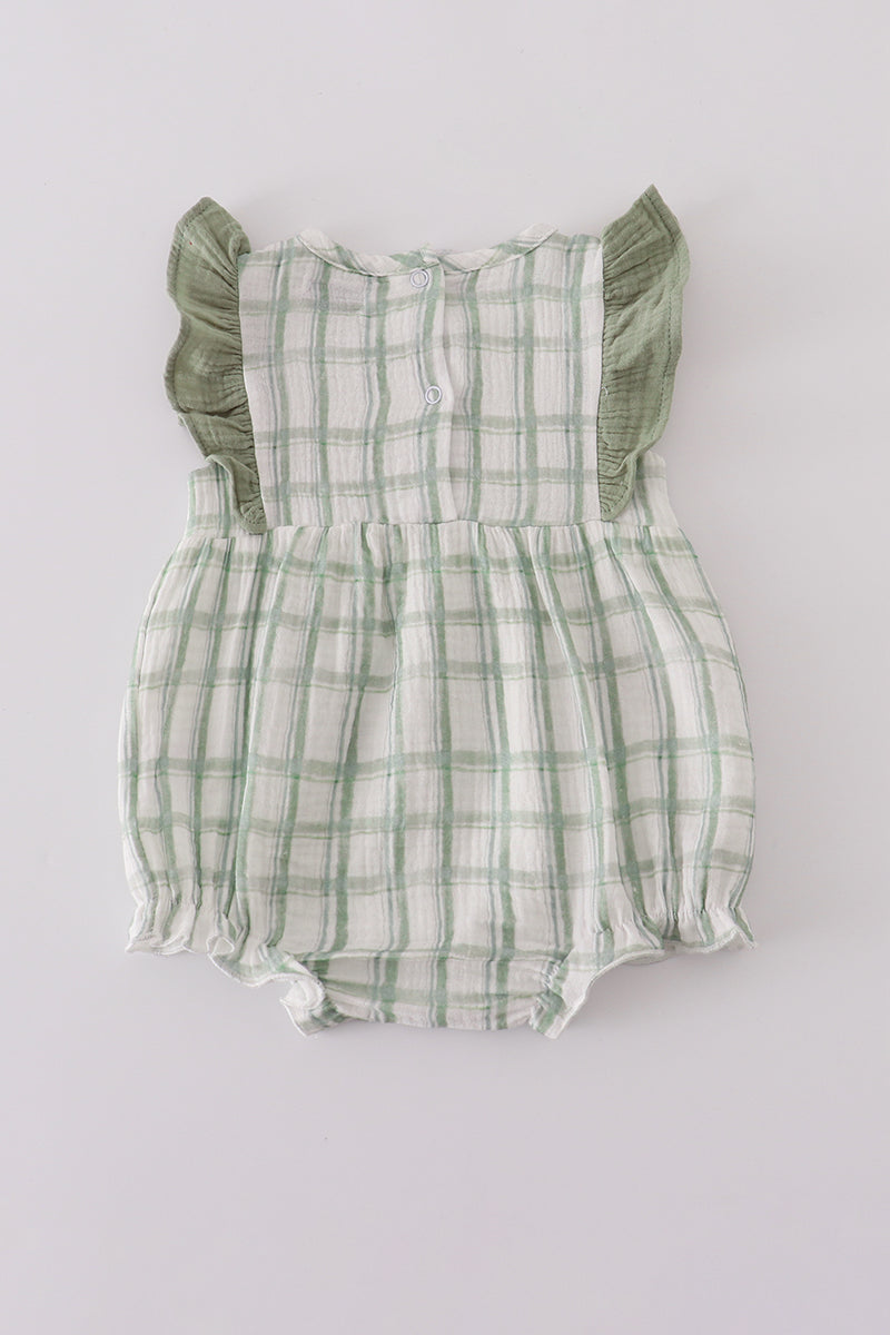 Green plaid baby romper with ruffled sleeves on a light gray background