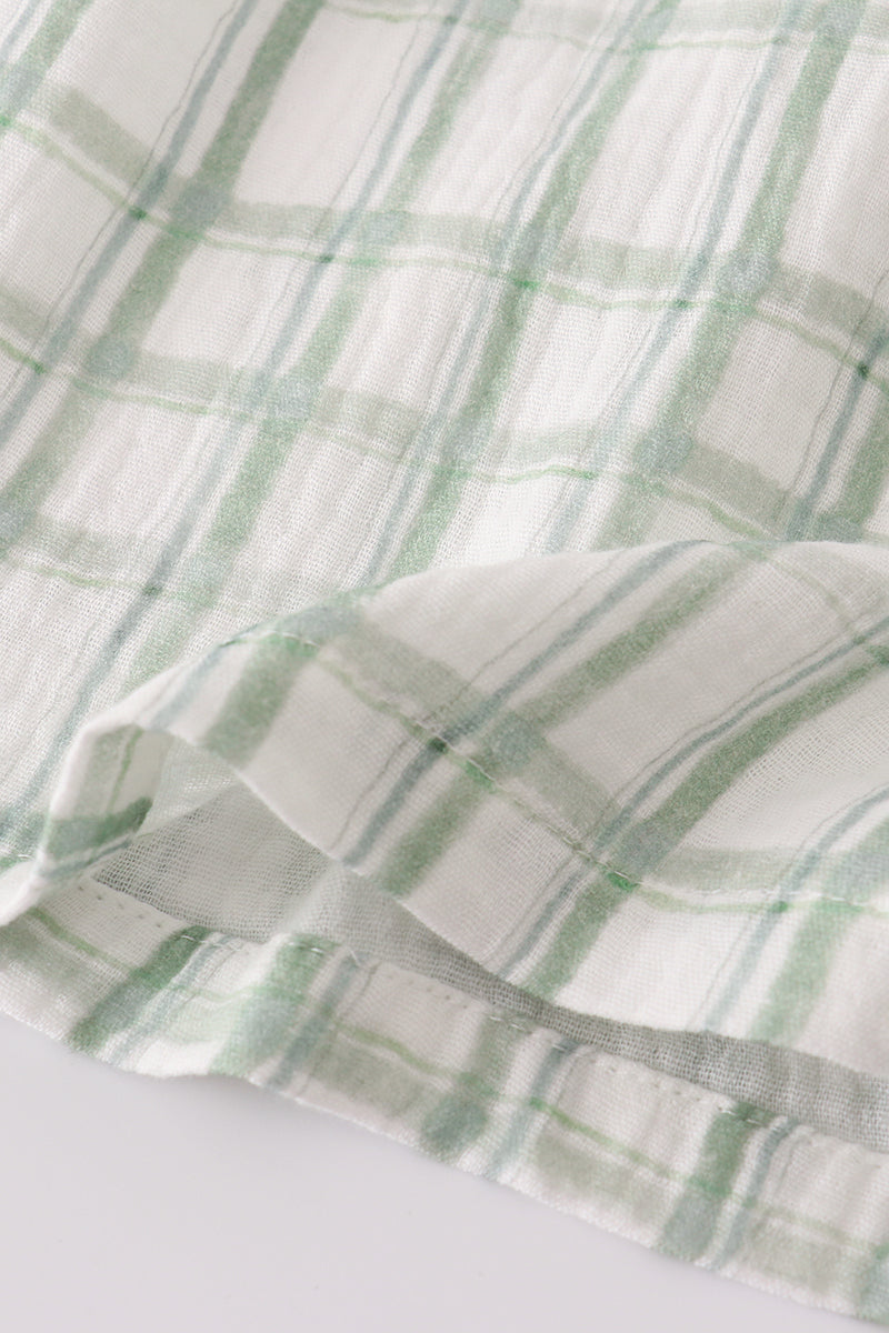 Close-up of green and white checkered fabric on a light background