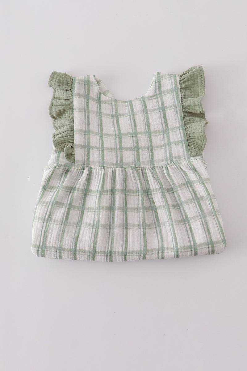 Green plaid baby romper with ruffled sleeves on a light gray background