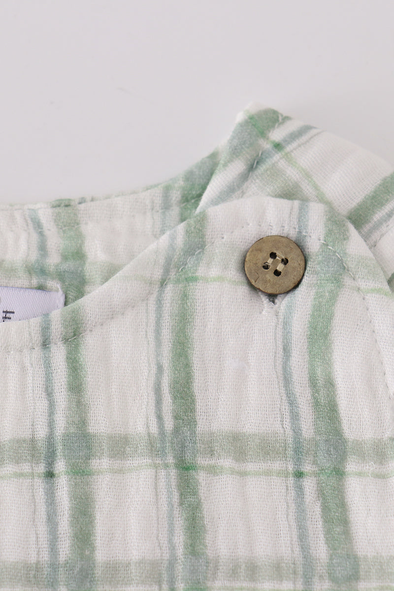 Close-up of a plaid fabric with a button on a white background