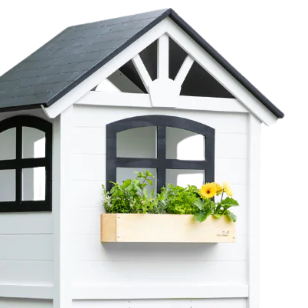 White playhouse with black accents and a window box filled with plants on a white background