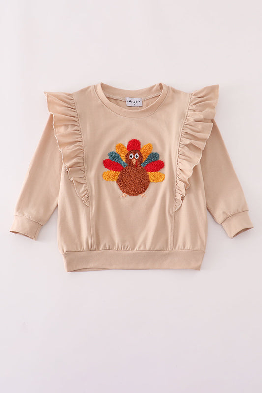 Beige sweatshirt with a colorful turkey applique on a white background