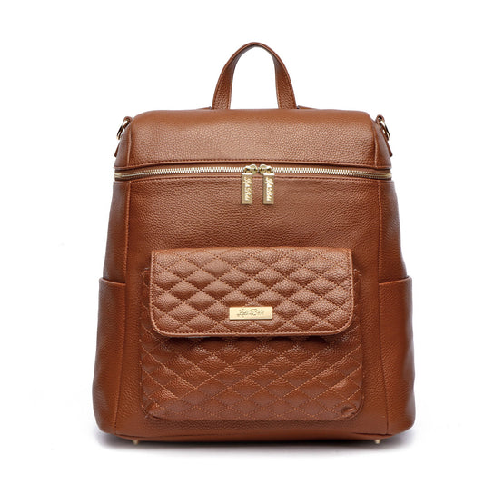 A caramel brown premium vegan leather diaper bag with a quilted design on the front pocket, featuring a top handle, a backpack strap, and a front zipper closure.