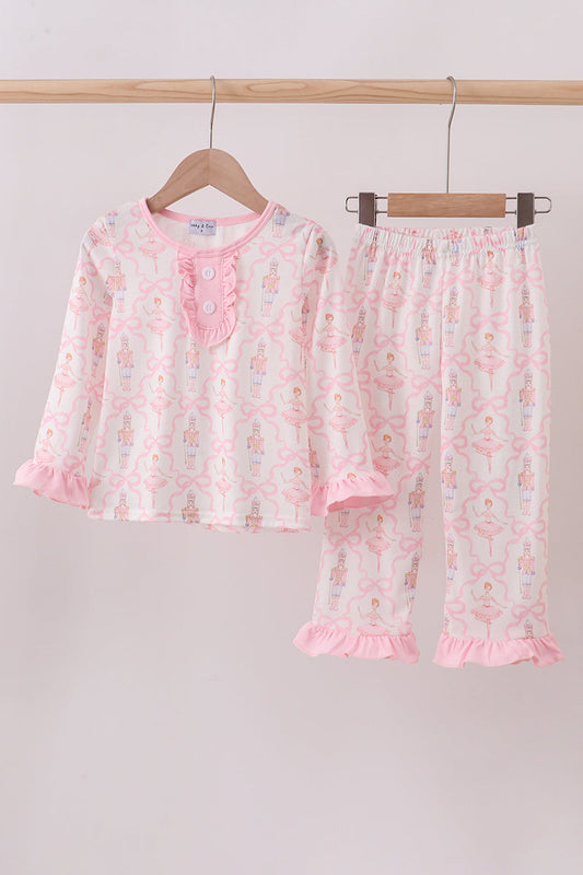 Children's pajama set with floral pattern on a hanger against a plain background