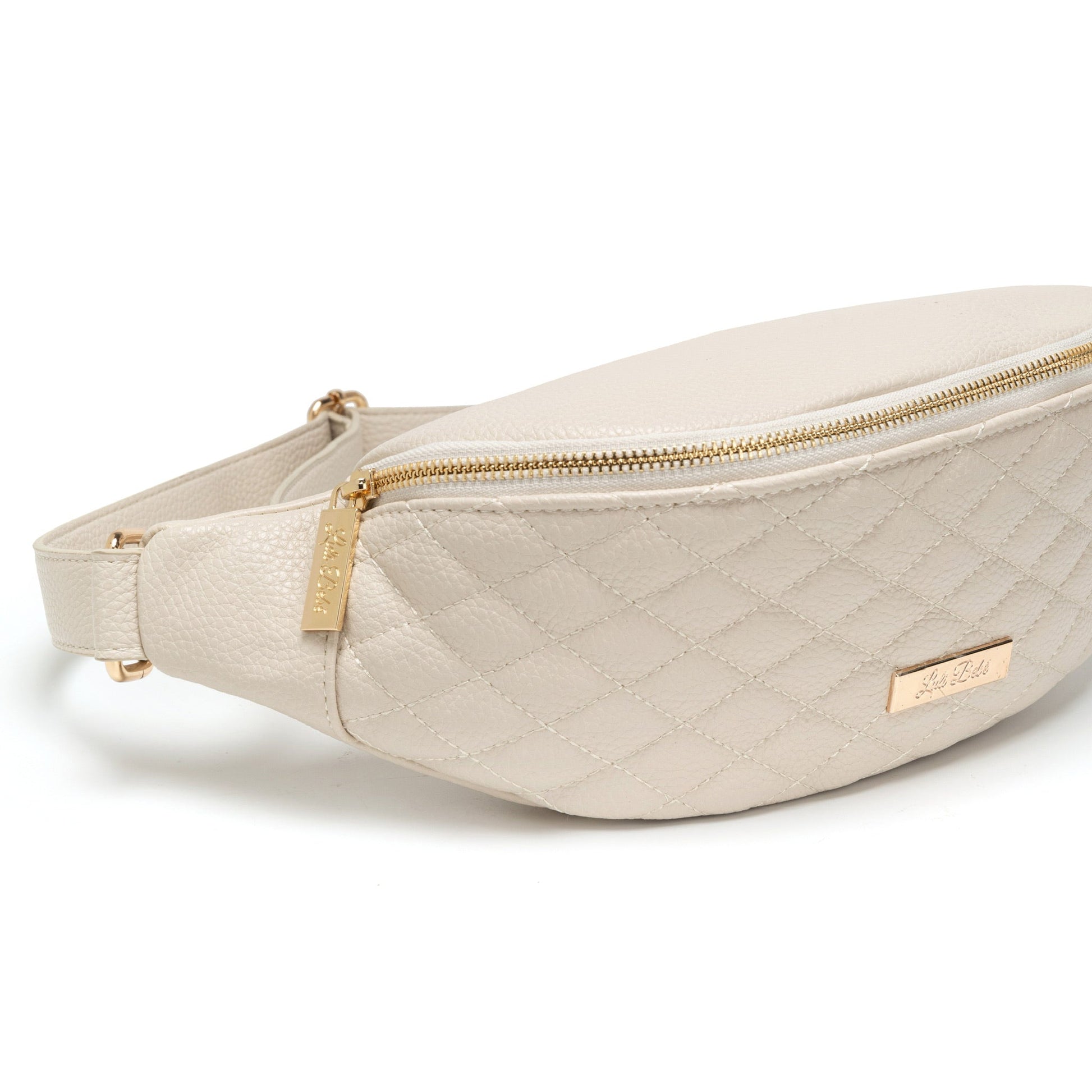 Beige quilted fanny pack with gold zippers on a white background