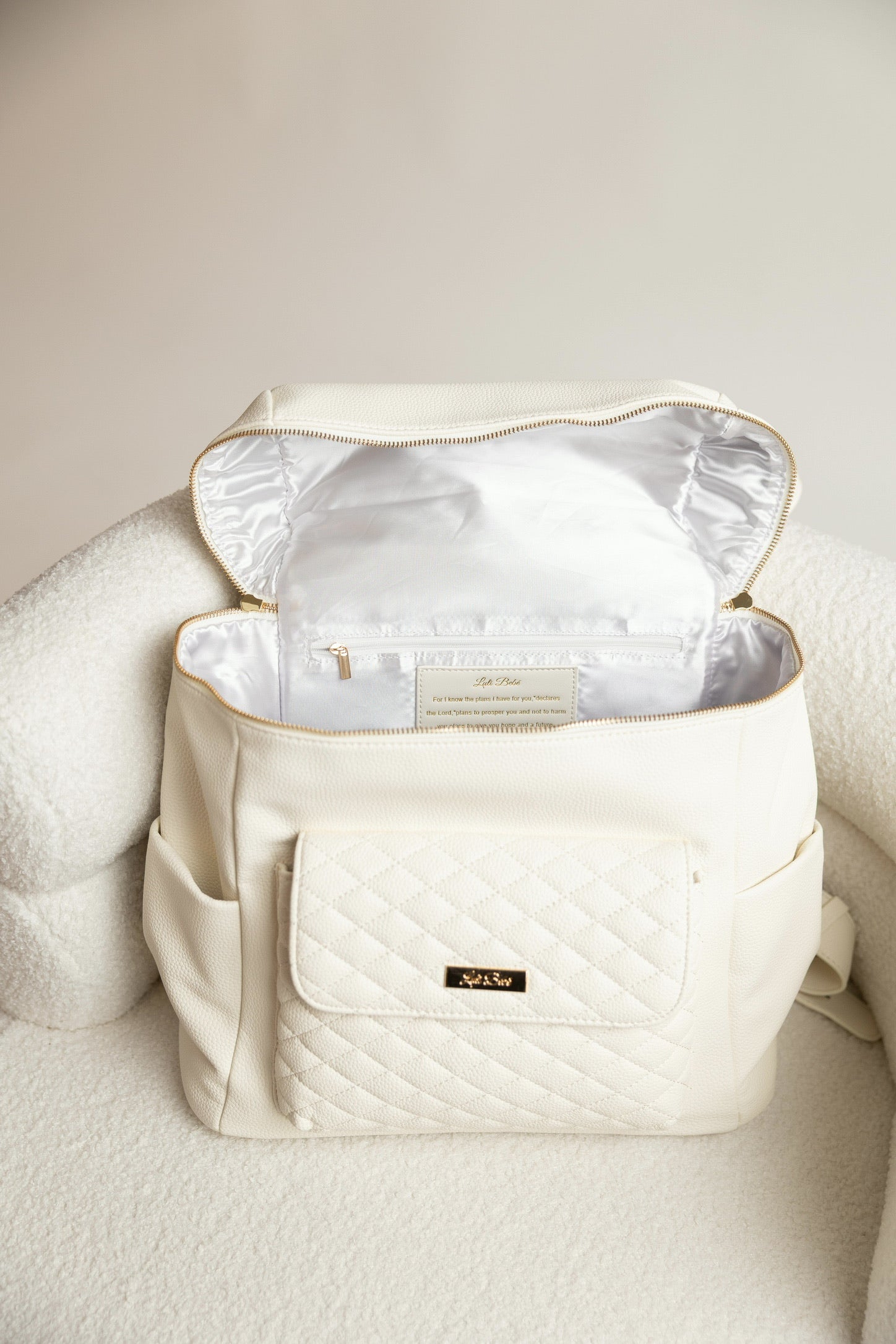 Beige backpack with a quilted design on a beige surface