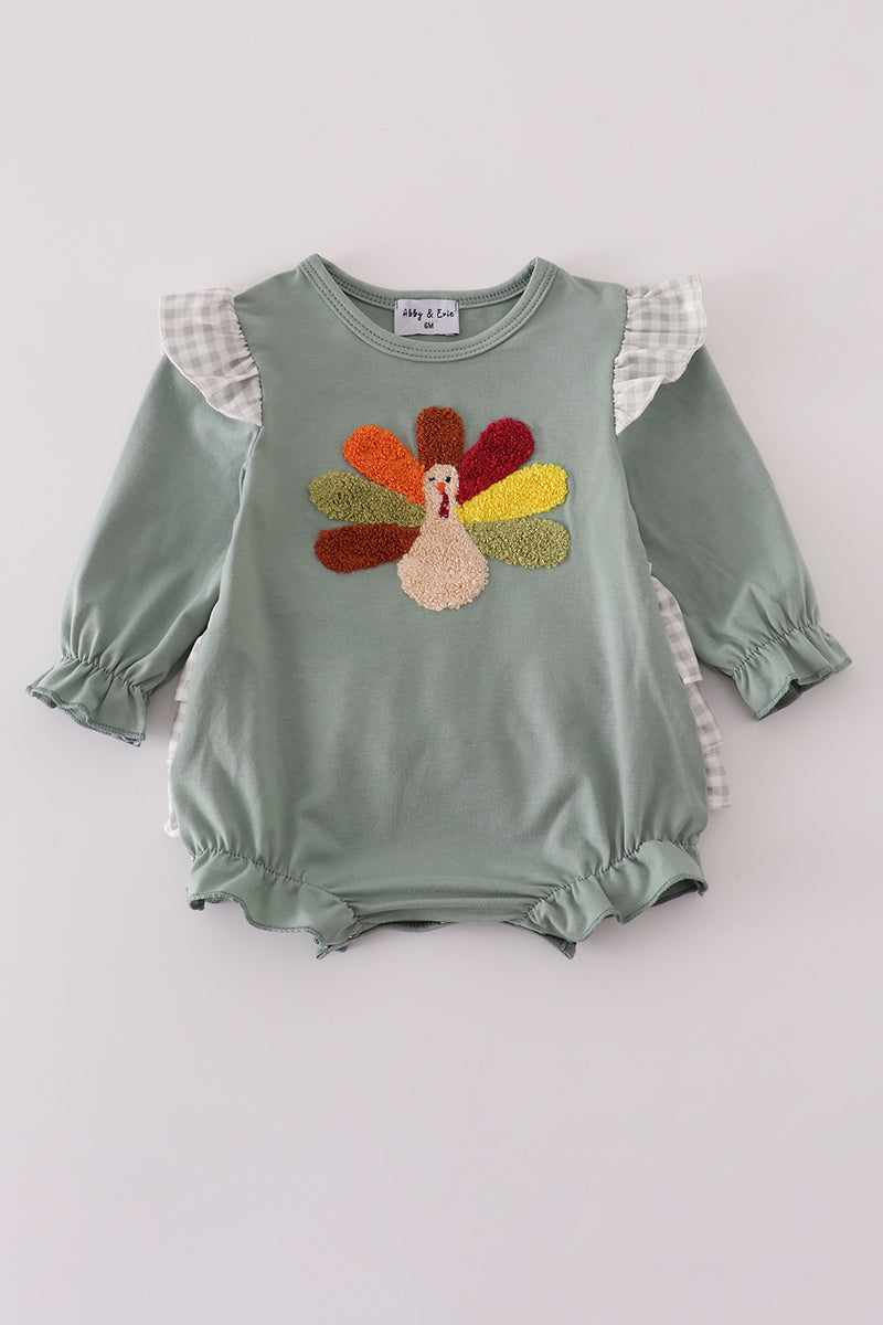 Green baby romper with colorful turkey design on a white background