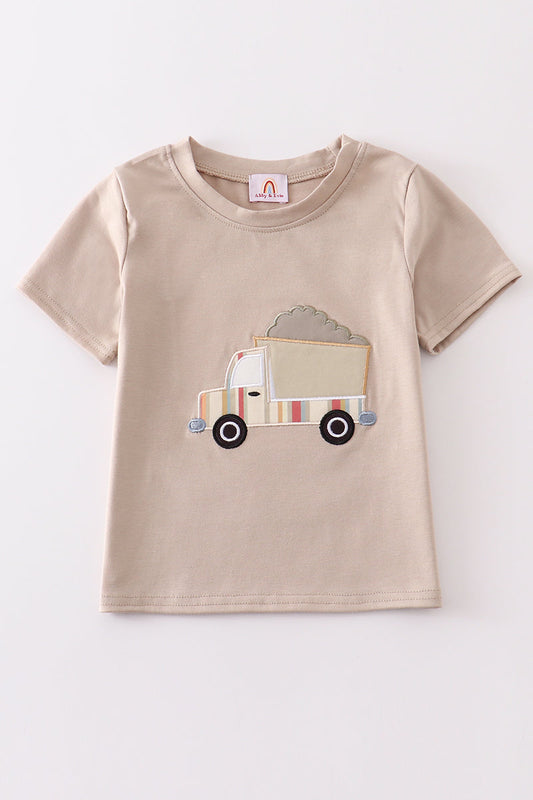 A khaki-colored short-sleeved top with a truck applique on the front.