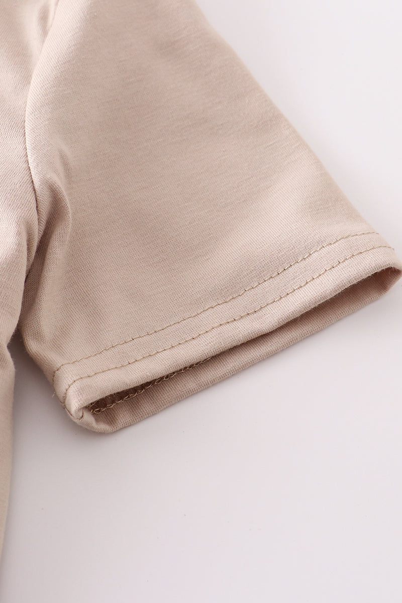Close-up of beige fabric with a visible seam on a white background.