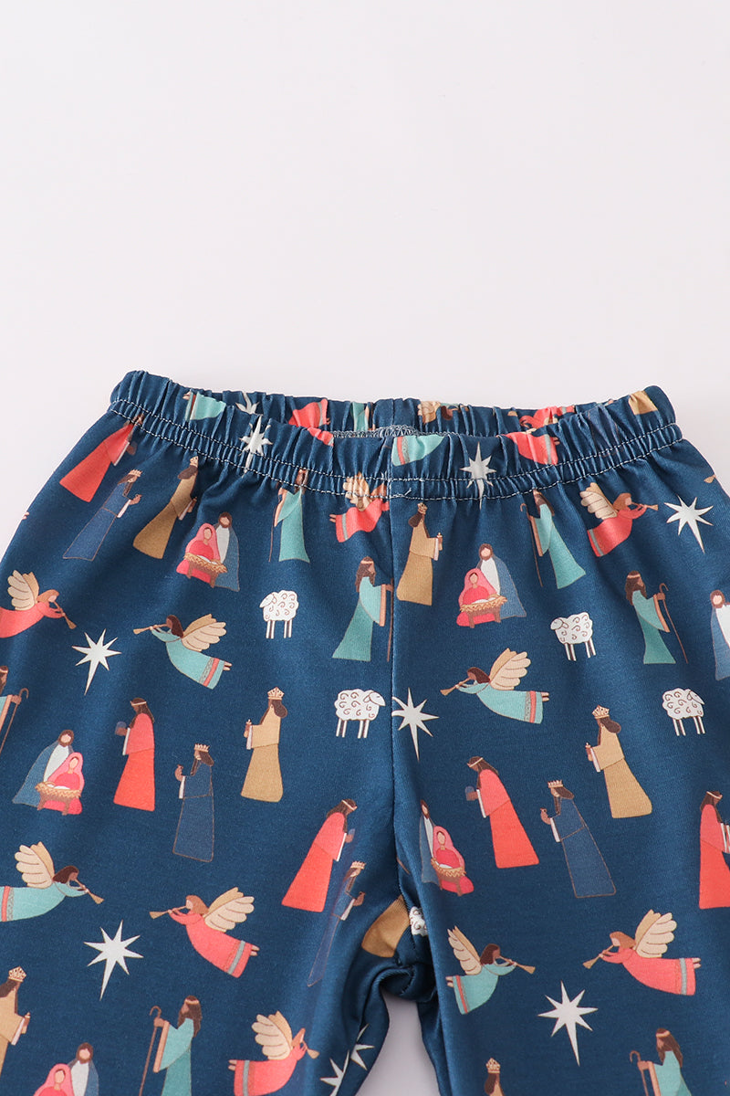 Navy blue shorts with a festive pattern of angels, stars, and other figures on a white background
