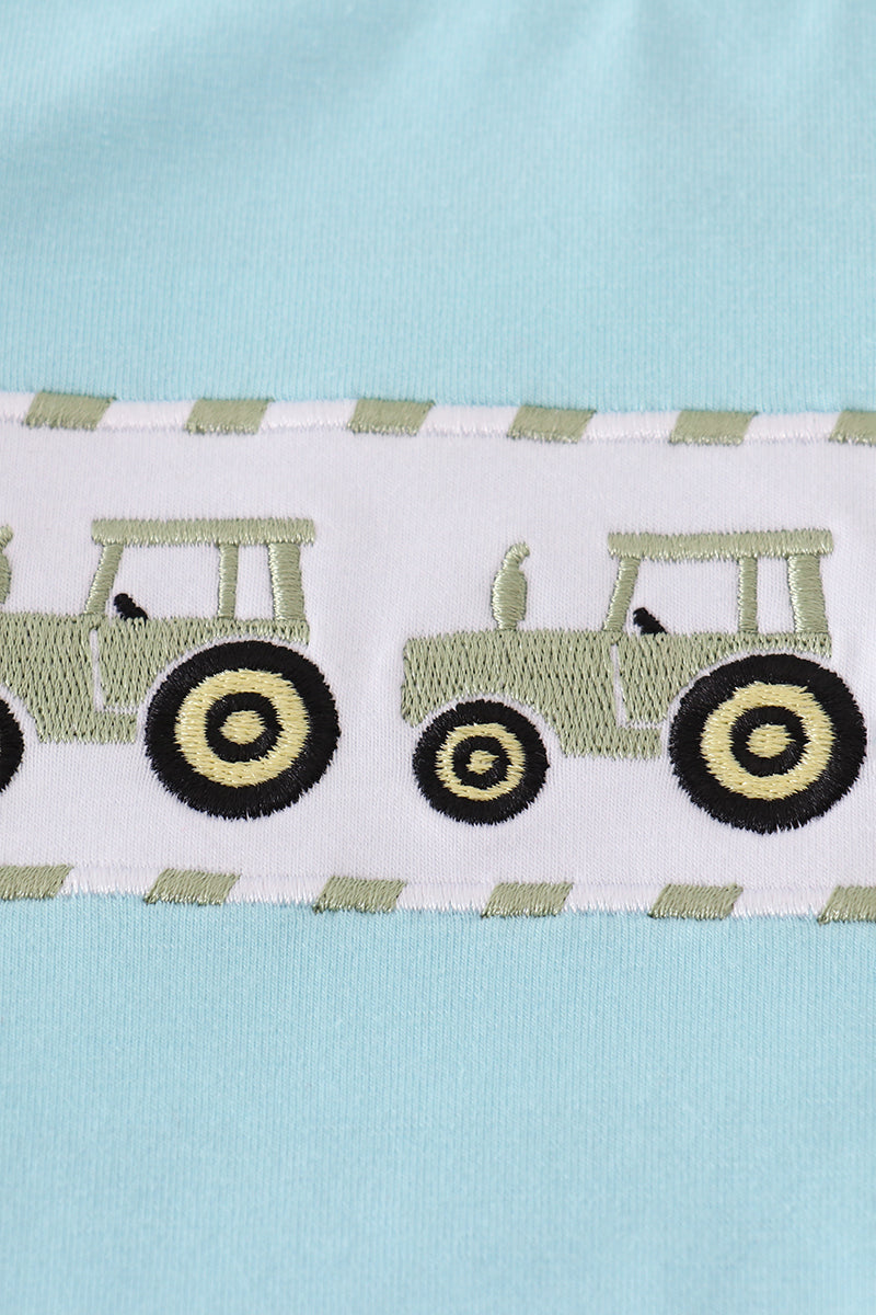 Embroidered tractors on a striped fabric with a light blue background