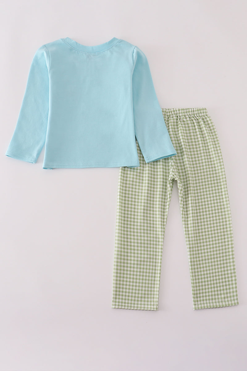 Light blue top and green checkered pants on a light gray background