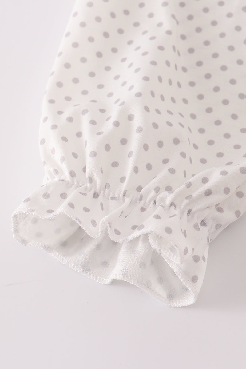 White fabric with gray polka dots on a light gray background