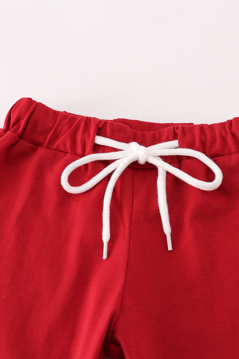 Red pants with a white drawstring on a white background