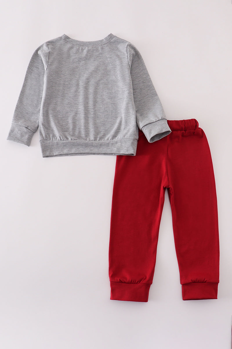 Gray sweatshirt and red pants on a light gray background