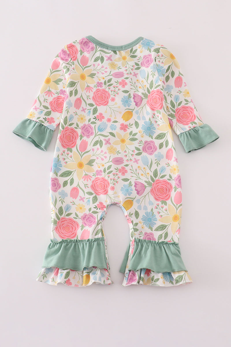 Floral baby romper with ruffled details on a light gray background