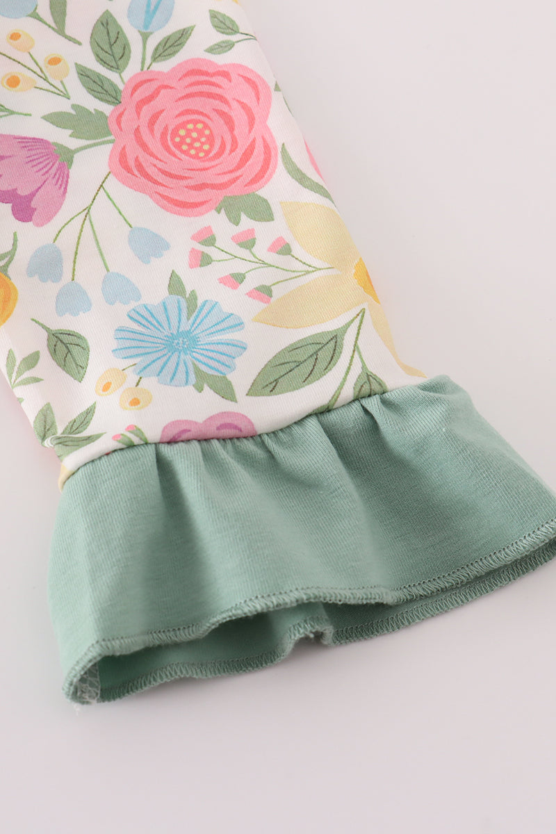 Floral-patterned fabric with a green ruffled edge on a light background