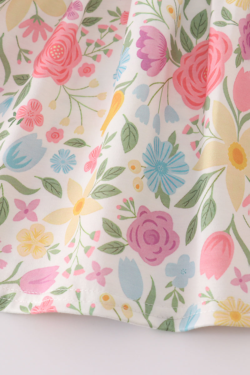 Floral fabric with pink, blue, yellow, and green flowers on a white background