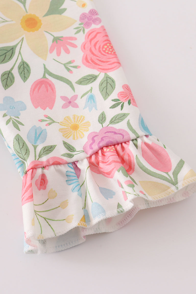 Floral-patterned baby romper with a ruffled bottom on a light background