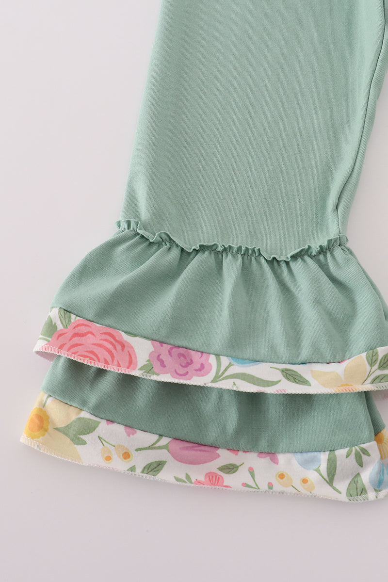 Green dress with floral hem on a light gray background