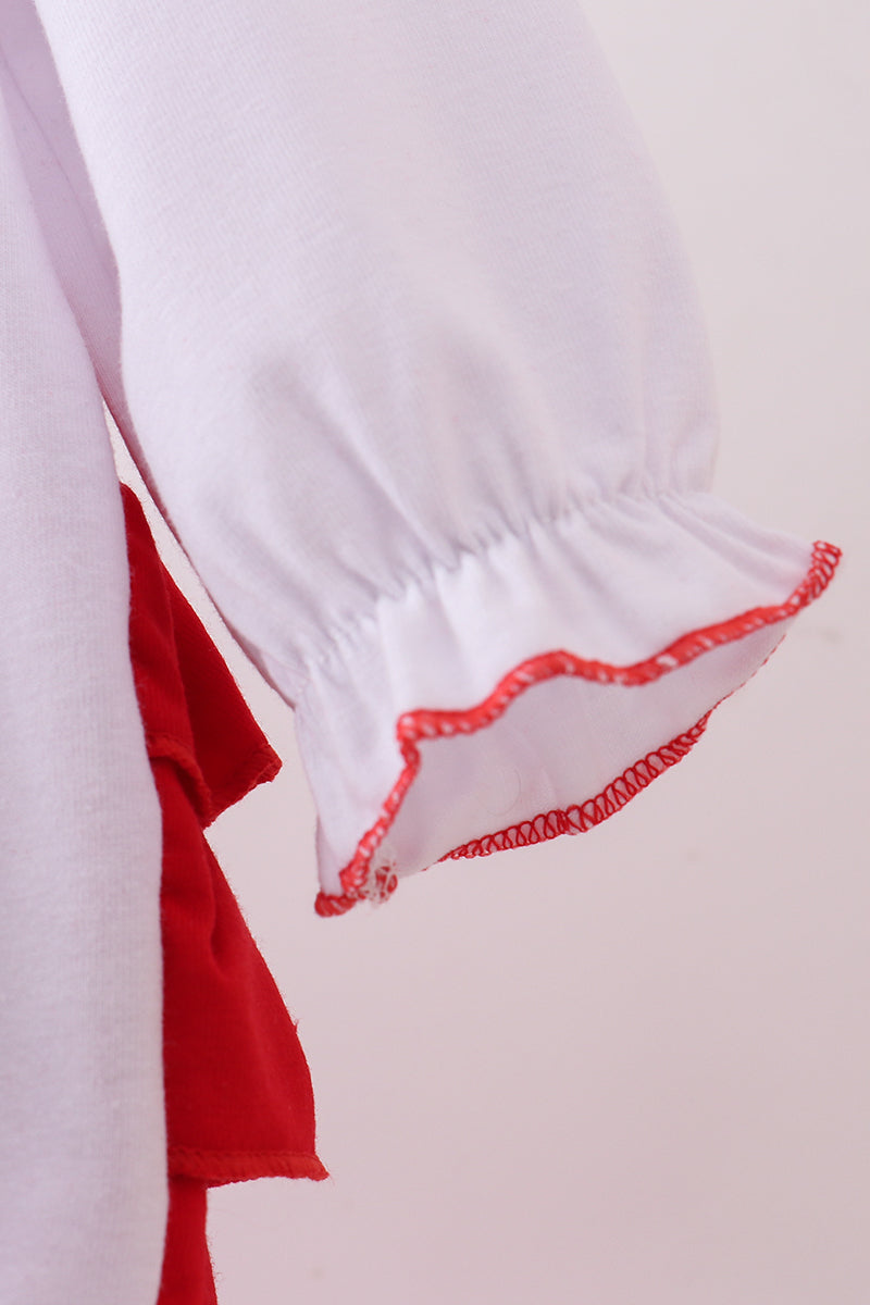 Close-up of a white garment with red trim on a light gray background