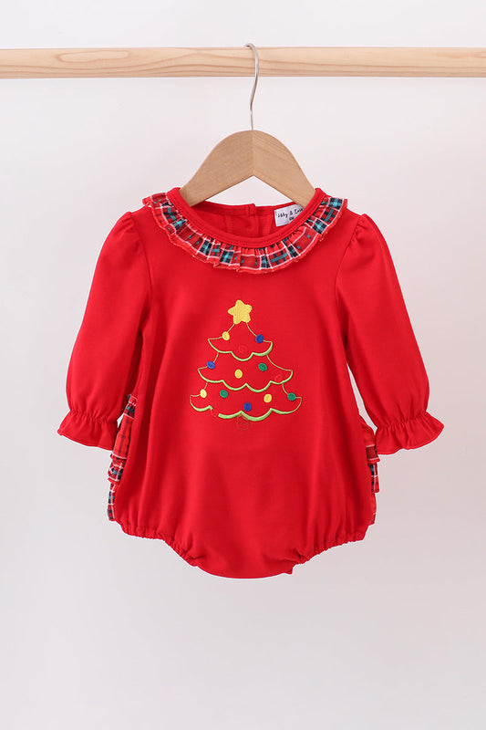 Red baby romper with Christmas tree design on a wooden hanger against a white background