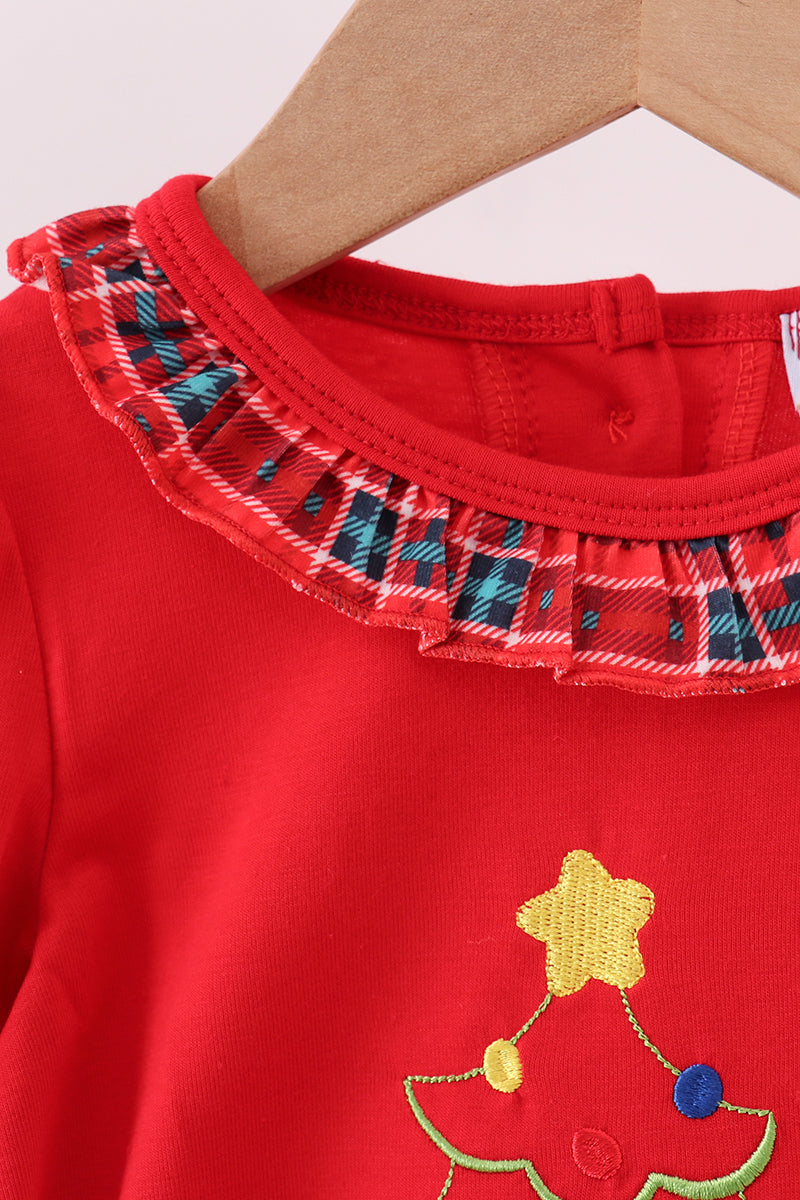 Red dress with plaid trim and embroidered design on a mannequin.