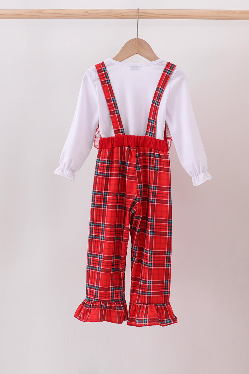 Red plaid overalls with a white shirt on a beige background