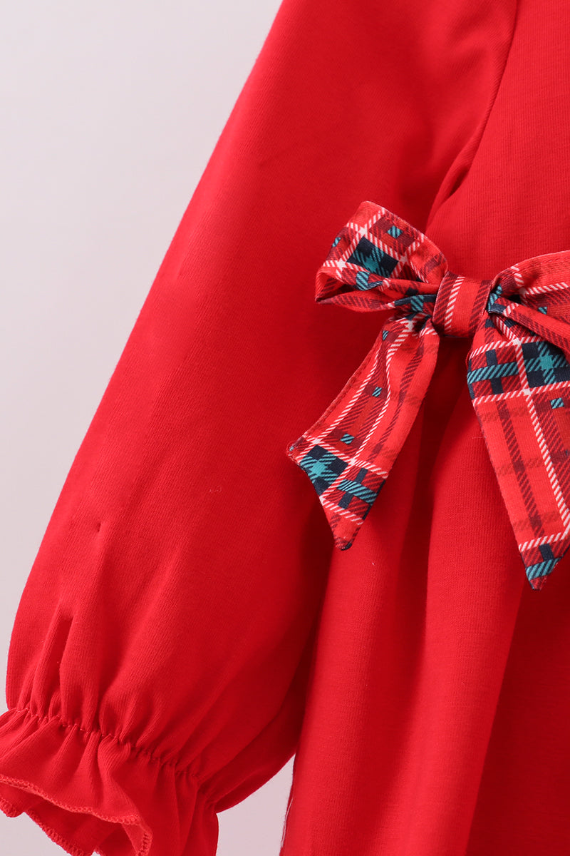 Red dress with a plaid bow detail on a light gray background