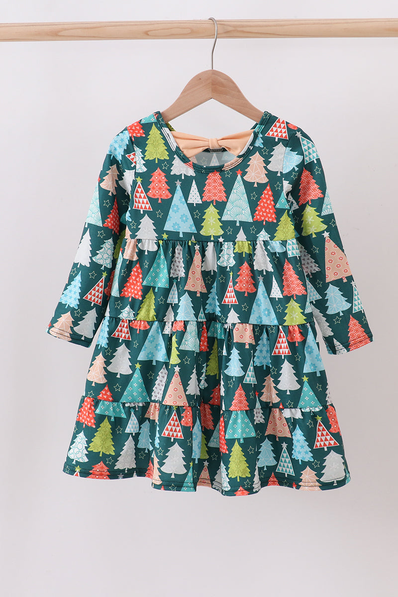 Children's dress with tree pattern on a hanger against a white background