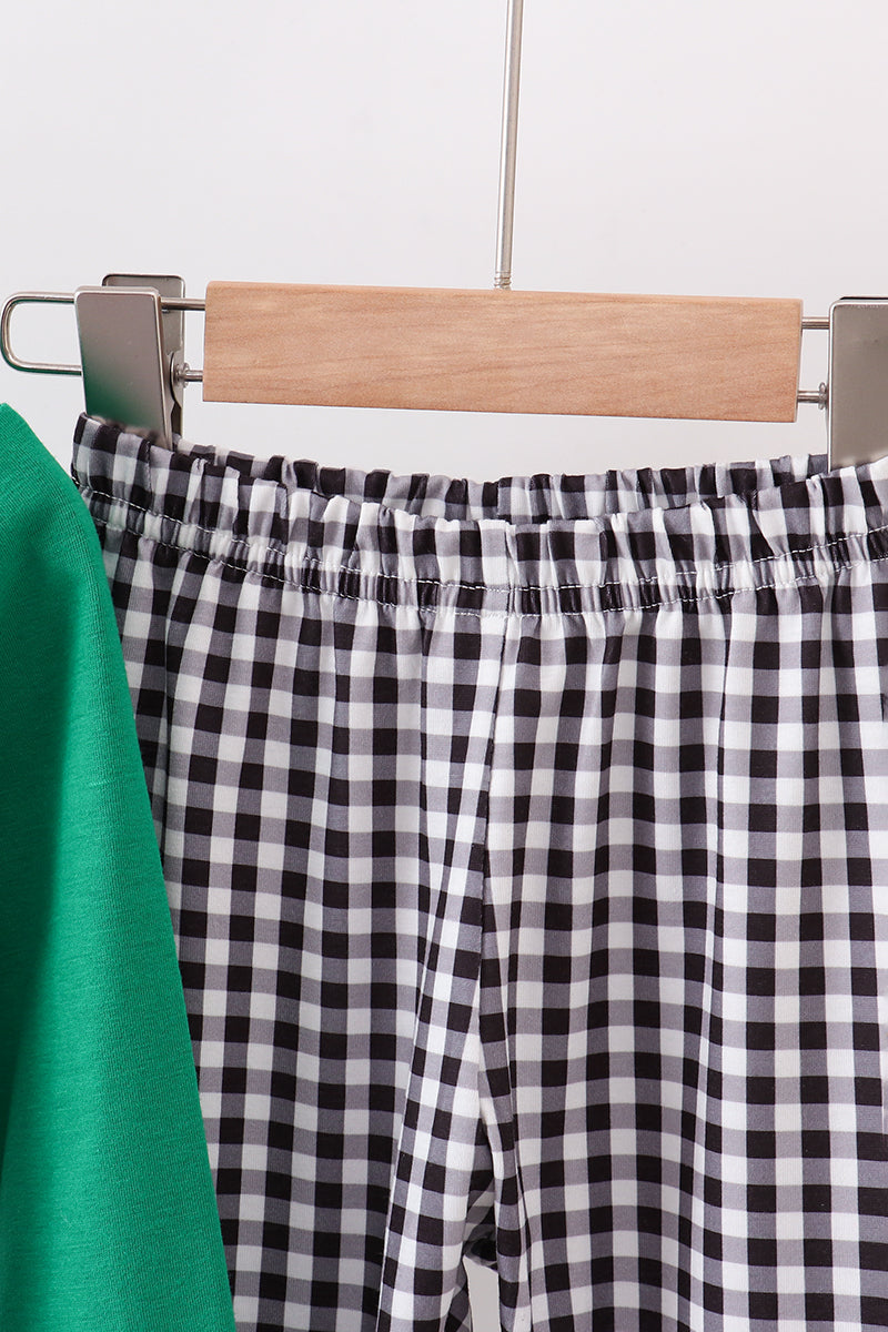Black and white checkered pants on a hanger against a neutral background