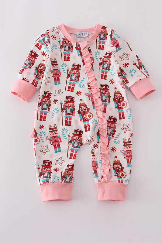 Baby onesie with nutcracker pattern on a light gray background