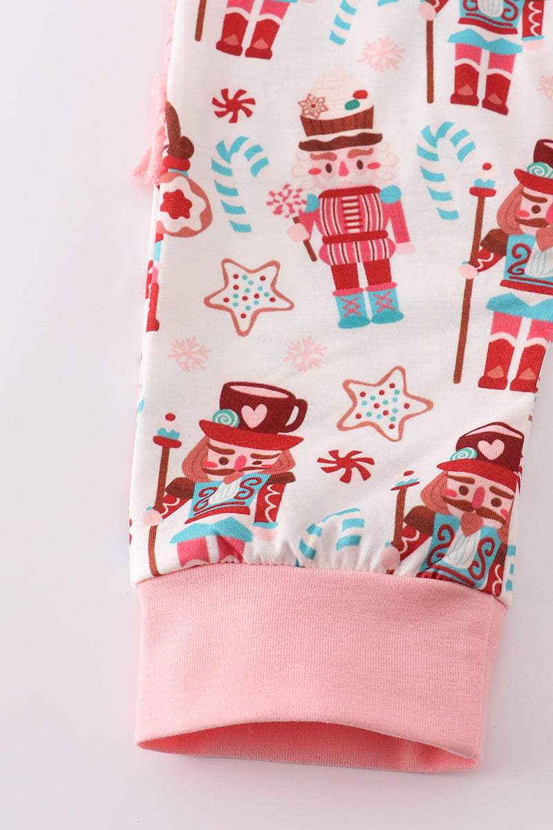Fabric with Christmas-themed design featuring nutcrackers and candy canes on a white background.