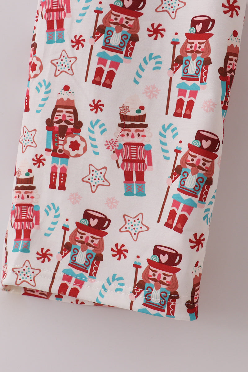 Fabric with nutcracker and candy cane pattern on a white background