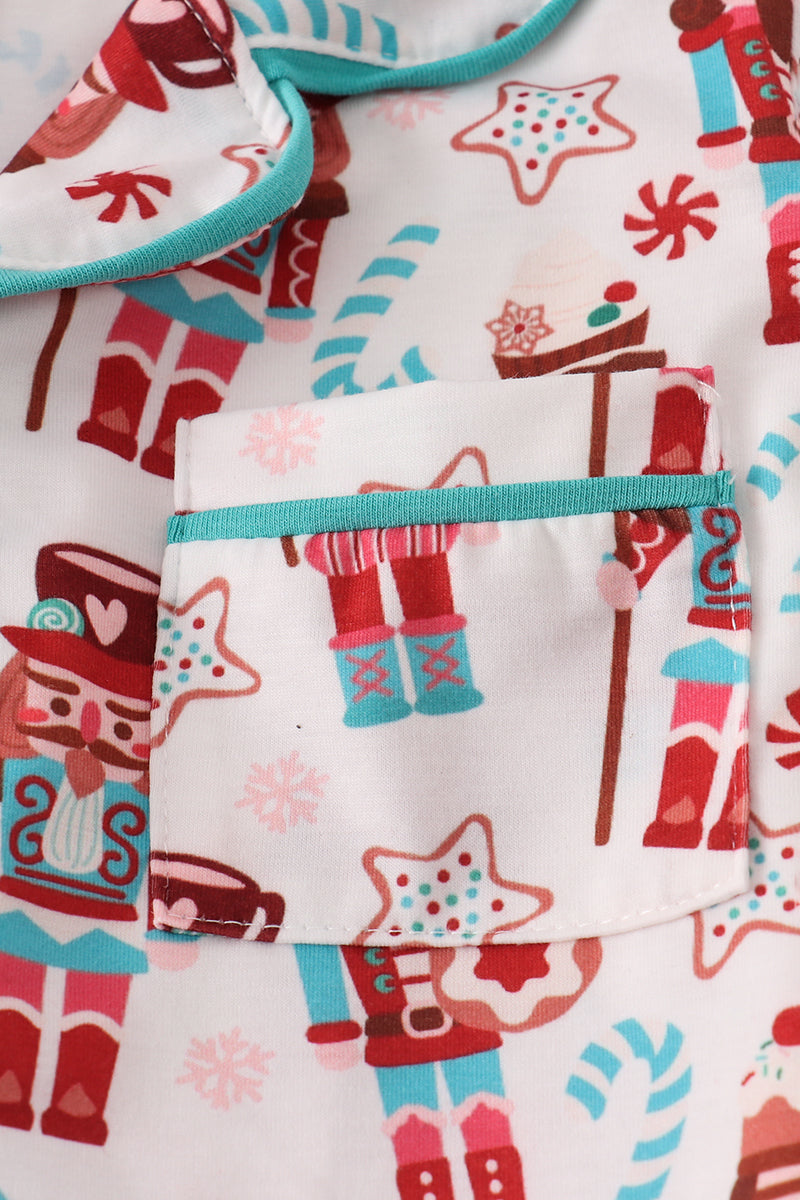 Children's pajama set with festive pattern featuring stars, candy canes, and gingerbread men.