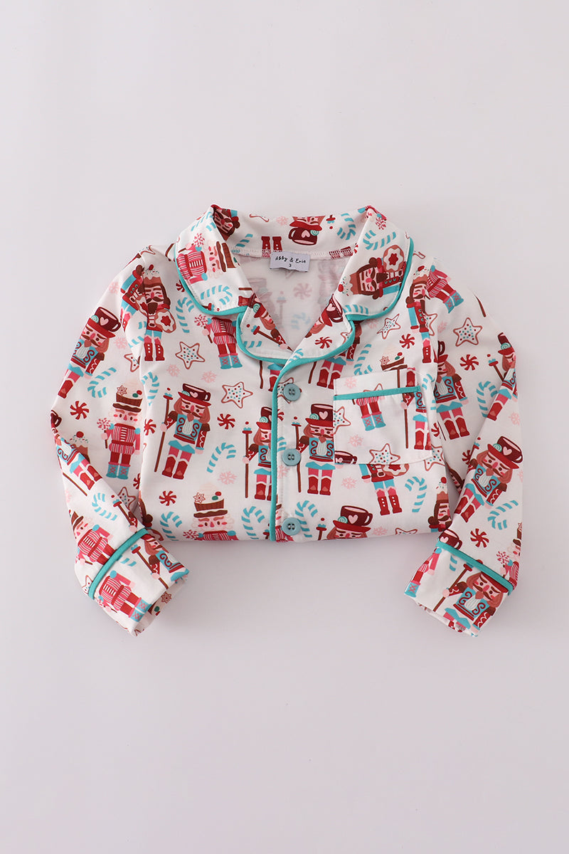 Children's pajama set with festive pattern on a light gray background