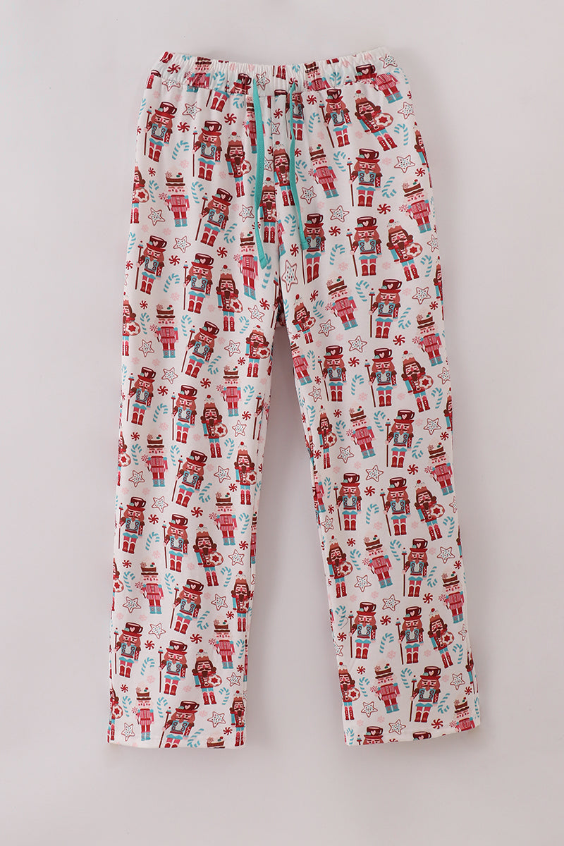 Flannel pajama pants with nutcracker and gift pattern on a light gray background