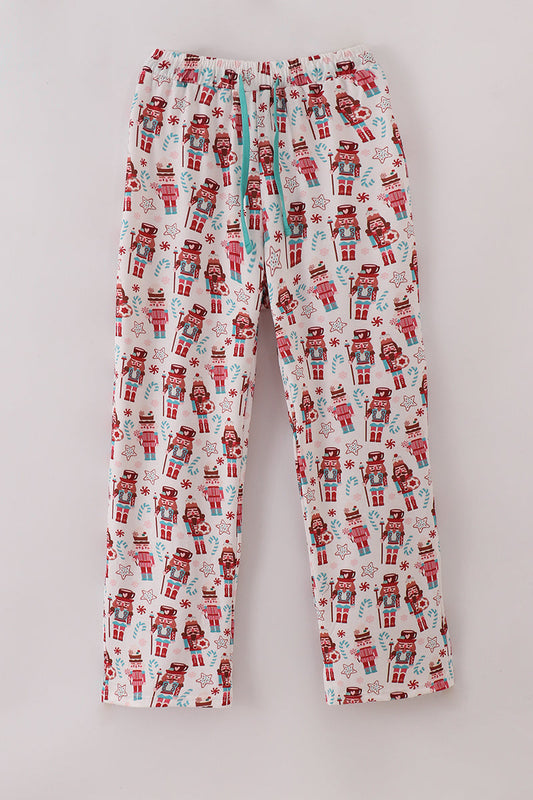 Flannel pajama pants with nutcracker and gift pattern on a light gray background