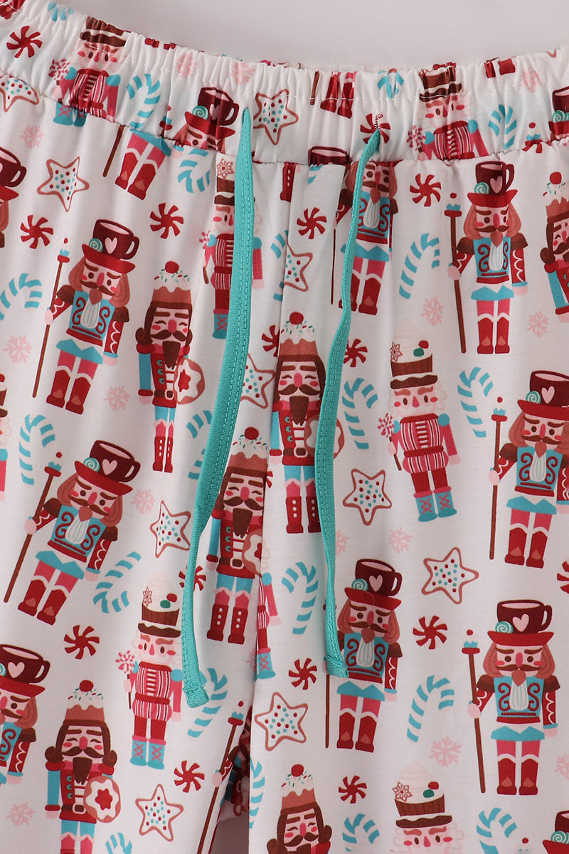 Pajama pants with nutcracker and candy cane pattern on a white background