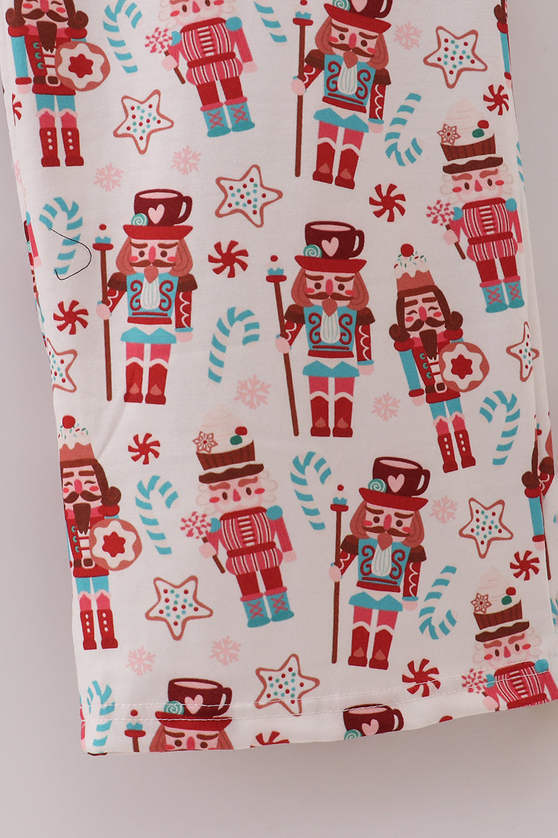 Fabric with nutcracker and candy cane pattern on a white background