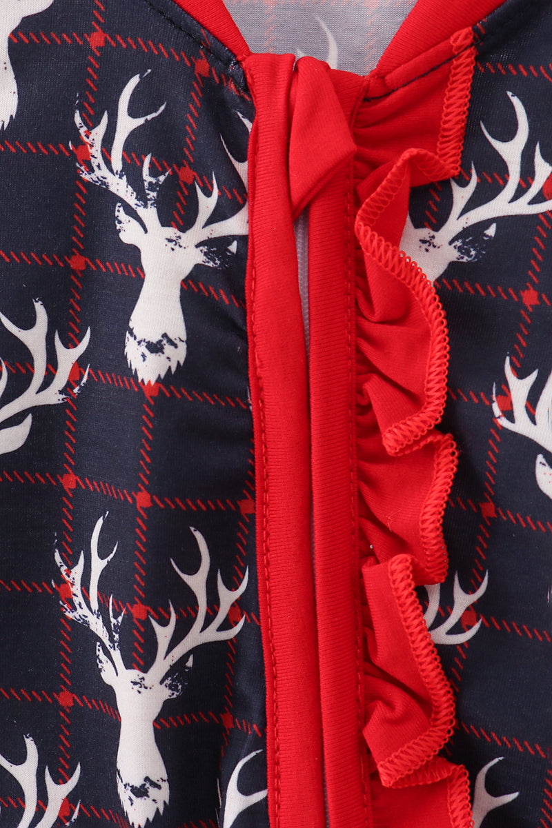 Close-up of a red zipper on a navy fabric with white deer antler pattern