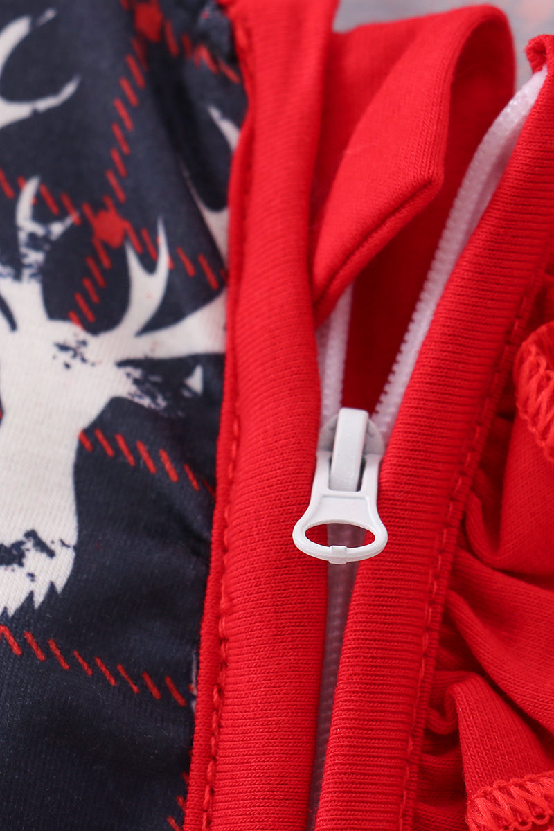 Close-up of a red zipper on a garment with a navy background featuring white patterns.