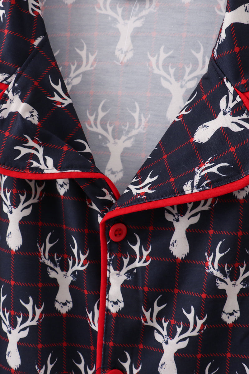 Navy pajama set with white deer heads and red accents on a gray background