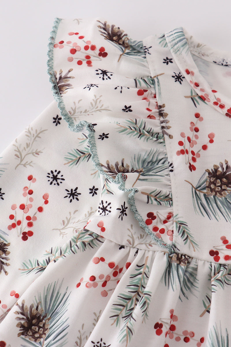 Close-up of a fabric with winter-themed pattern including pinecones, berries, and snowflakes on a white background.