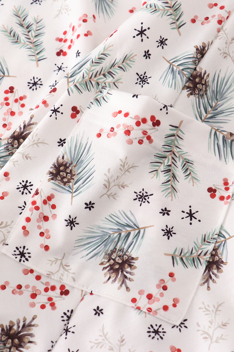 Christmas-themed fabric with pine branches, berries, and snowflakes on a white background.
