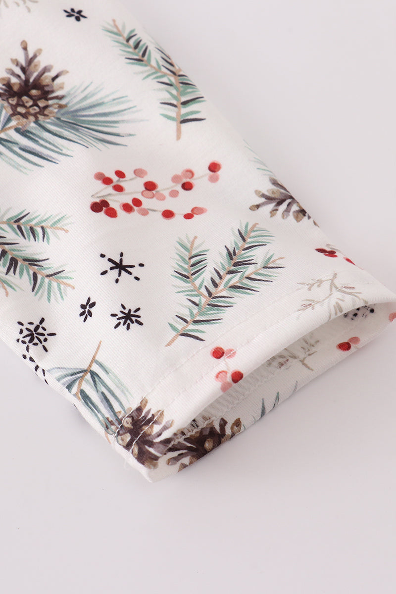 Gift box with Christmas-themed wrapping paper featuring pine branches, berries, and snowflakes on a white background.