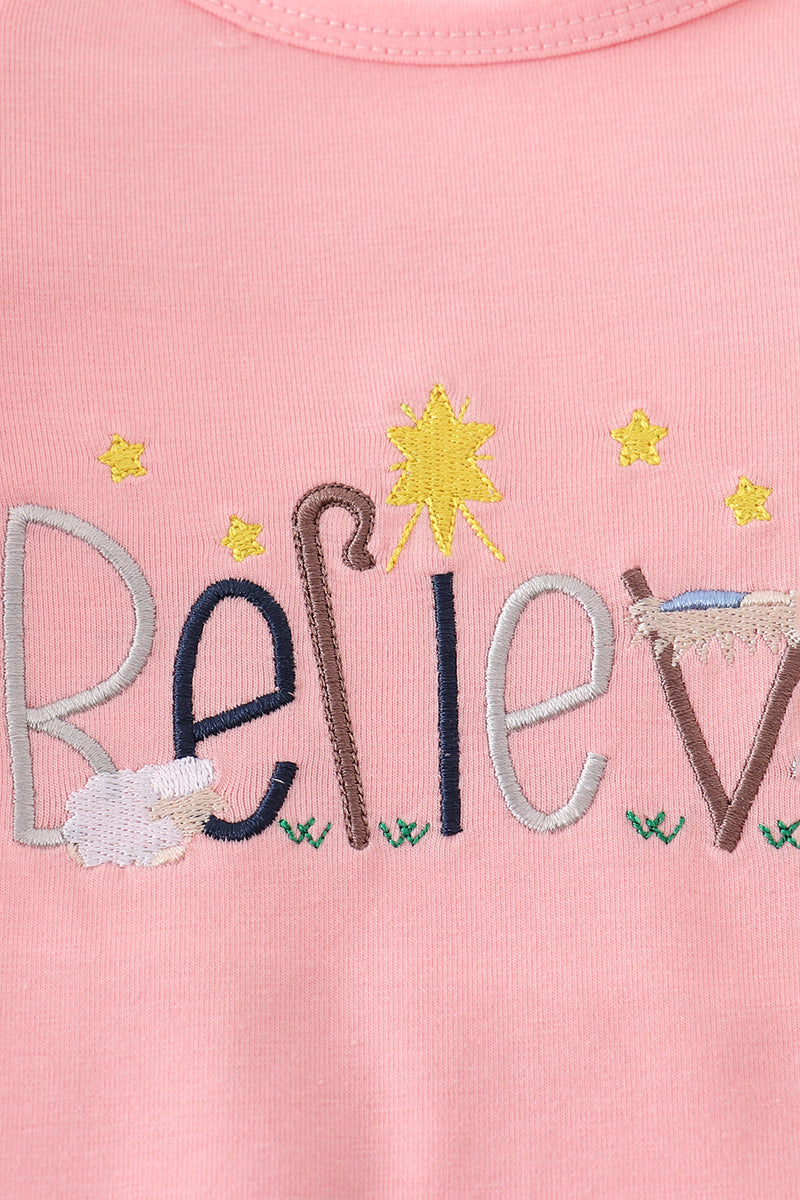Embroidered text and festive elements on a pink background